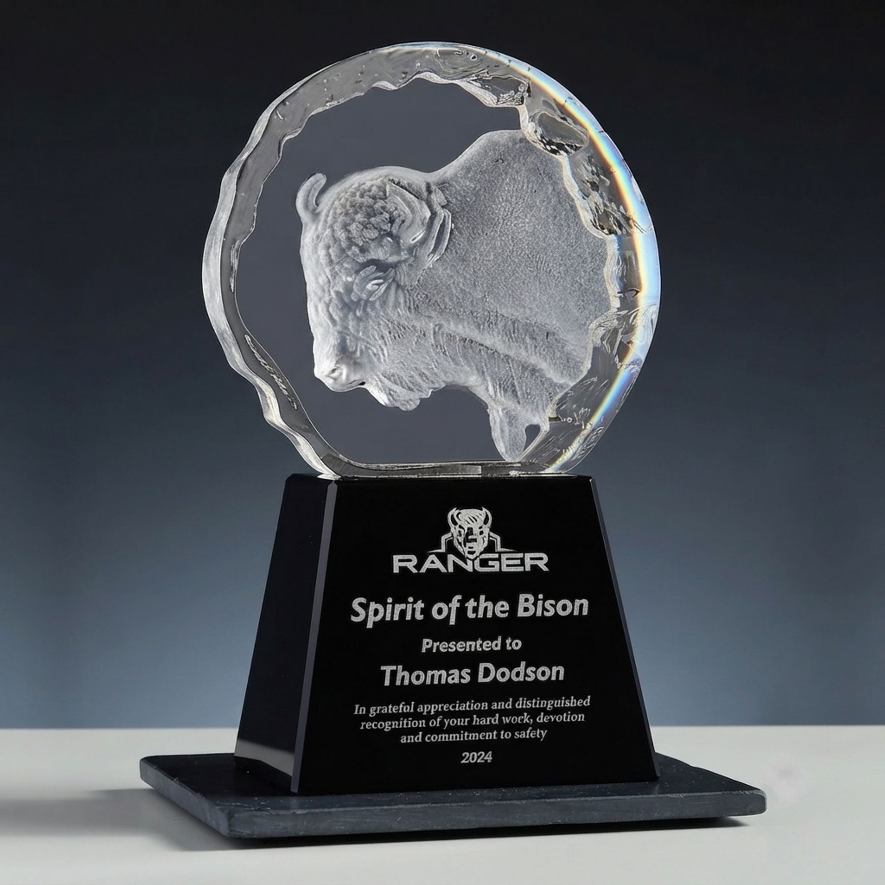 Bison engraved in clear crystal block on black base