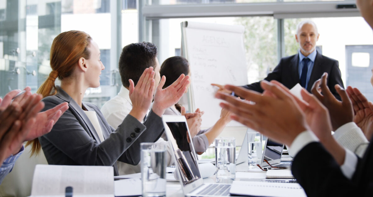 employees applauding a colleague on doing a great job